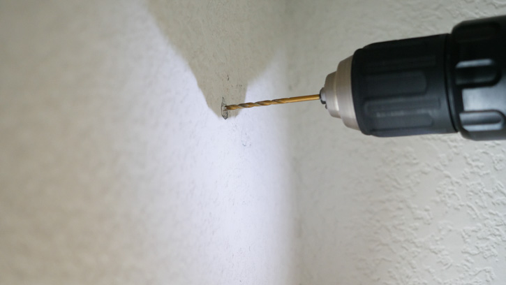 Make a pilot hole to test your wall before hanging your blackout curtains