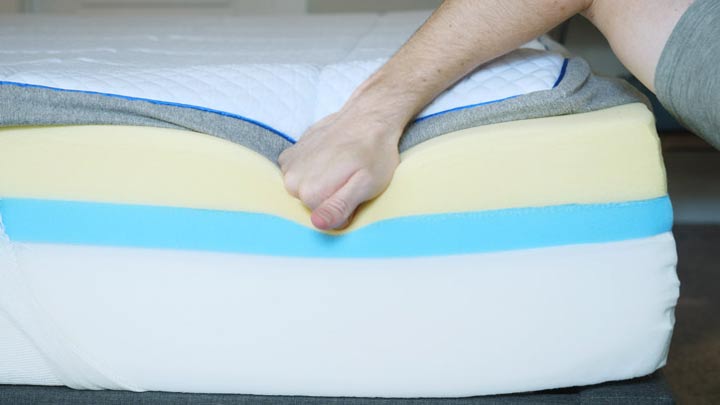 A man presses into a memory foam mattress