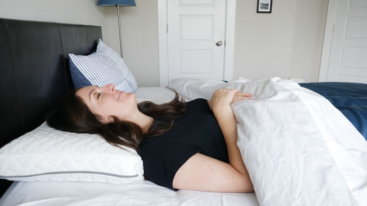 A woman sleeps on her back with the TEMPUR-Cloud pillow.