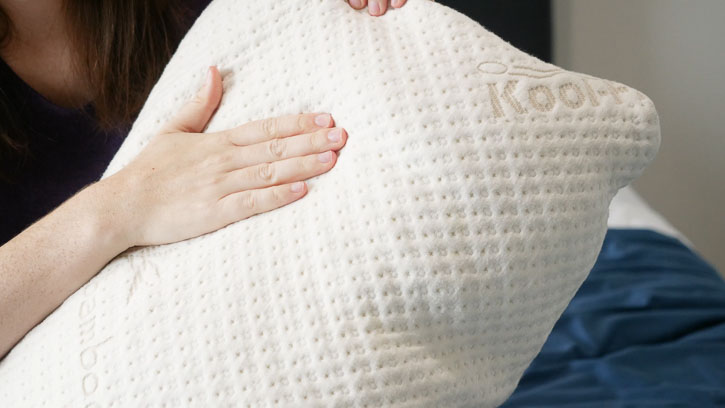 A woman runs her hand across the Snuggle-Pedic pillow