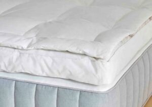A close shot of the fluffy Brooklinen topper sitting on a bed