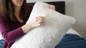 An image of a woman holding the coop home goods original pillow