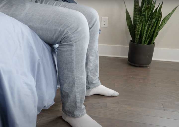 man sitting on edge of a bed