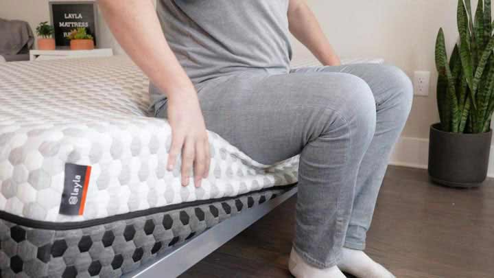 man sitting on the edge of the Layla mattress