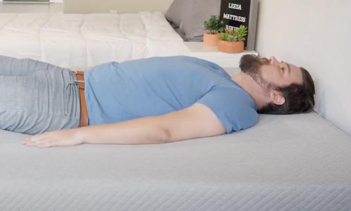 A man sleeps on his back on the Leesa mattress