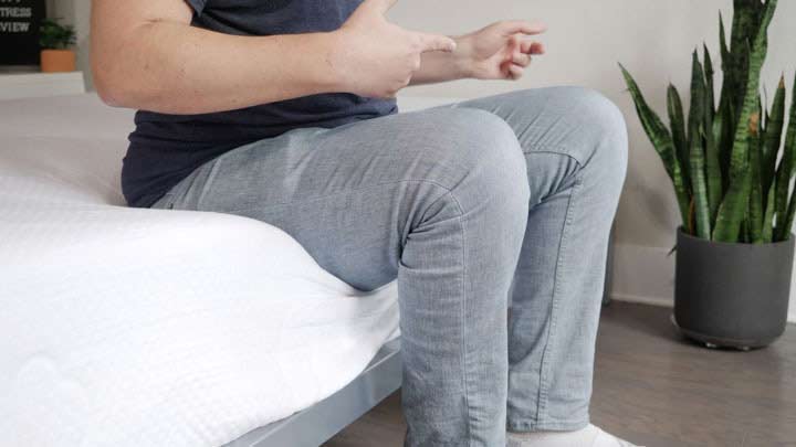 A man sits near the edge of the Puffy mattress