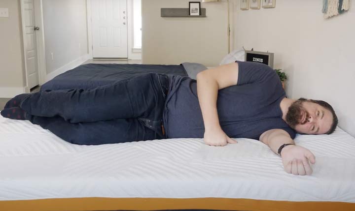 A man sleeps on his side on the Zinus mattress