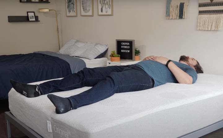 A man sleeps on his back on the Casper Hybrid mattress