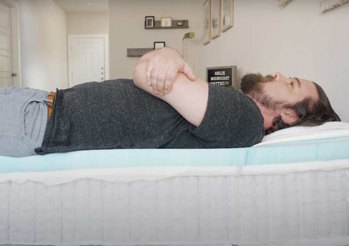 man laying on his back on the Helix Midnight mattress