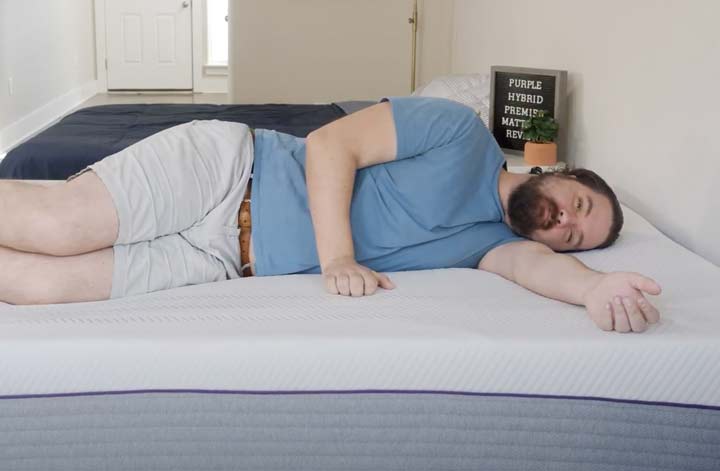 A man sleeps on his side on the Purple Hybrid Premier mattress