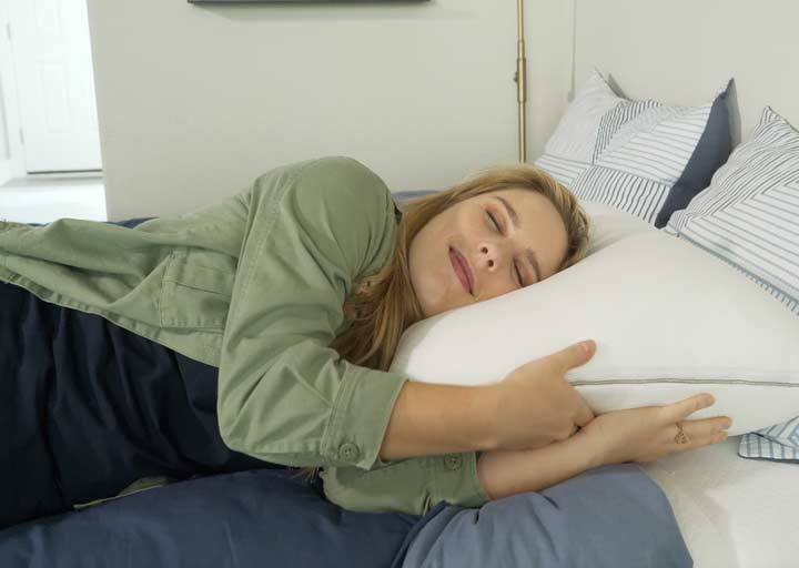 A woman sleeps on her side on a True Temp Pillow.