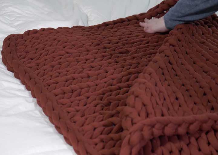 A weighted blanket is stretched across a mattress