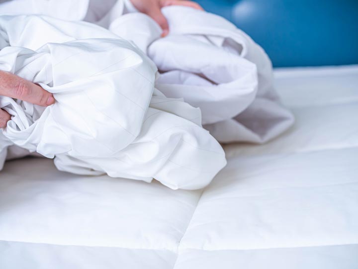 Examining sheets for bed bugs. How to Identify Early Signs of Bed Bugs