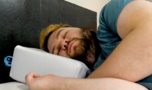 Pillow Cube Side Sleeping Pillow Cube - A man sleeps on his side while using the Pillow Cube