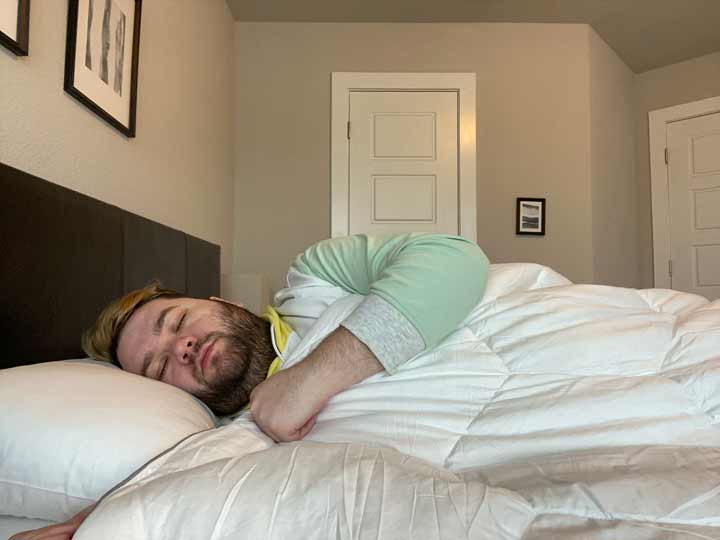 Layla Comforter Review - A man sleeps on his side with the Layla Comforter.