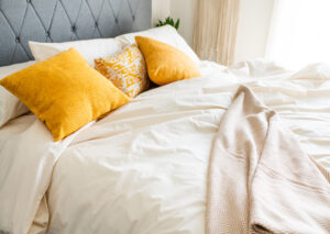 The Best Percale Sheets - An image of a bed made with the American Blossom sheets with orange pillows
