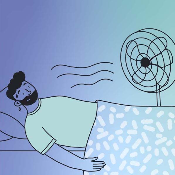 Man sweating in bed with fan blowing cool air