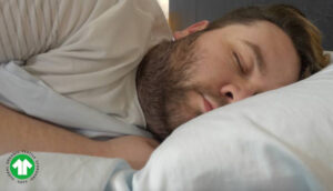 A man sleeps on his side with the Birch Organic Sateen sheets.