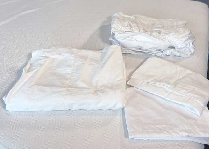 A picture of the sheet set pieces on top of a bed.