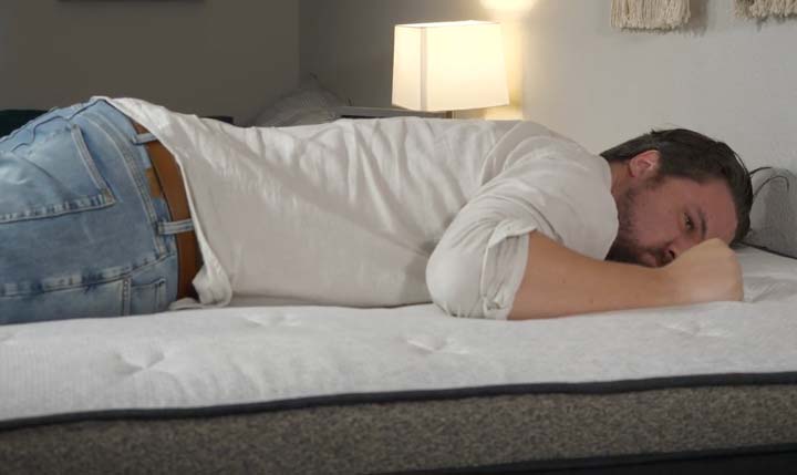 A man sleeps on his stomach on the Helix Dawn Luxe