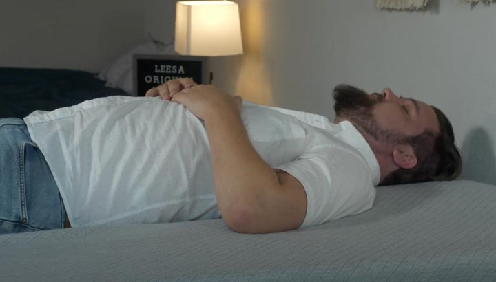 A man sleeps on his back on the Leesa Original Hybrid