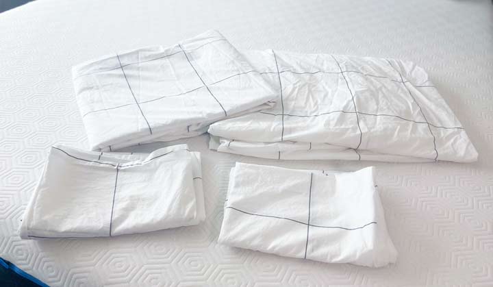 A picture of what the Brooklinen Classic Core Sheet Set includes, sitting on a bed.