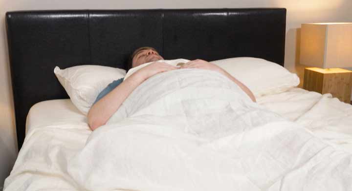 A man sleeps in the Brooklinen Linen Sheets.