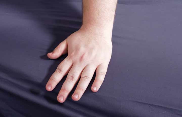 A hand brushes across the Brooklinen Luxe Sheets. A hand brushes across the Brooklinen Luxe Sheets.