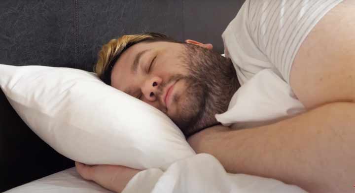 A man sleeps on his side on Serta Arctic Cooling Sheets