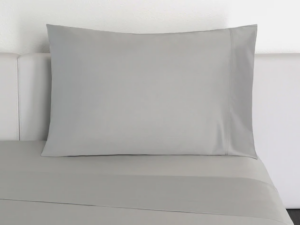 Best Bamboo Sheets - An image of a bed sheet with a pillow propped up against a headboard.