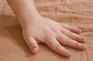 A hand brushes over the Parachute linen sheets