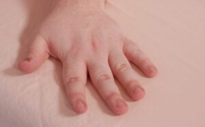 A hand brushes across the Pure Parima Yalda sheets.