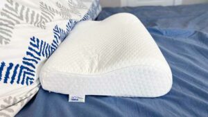 TEMPUR-Neck Pillow The TEMPUR-Neck Pillow on a bed.