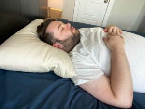 A man sleeps on his back on a Birch pillow