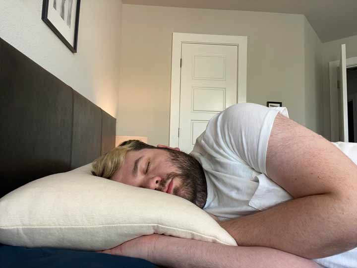 A man sleeps on his side on a Birch pillow