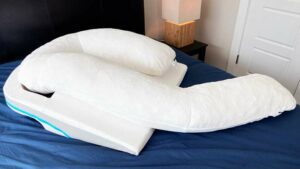 The Medcline Shoulder Relief Body Pillow placed on a bed.