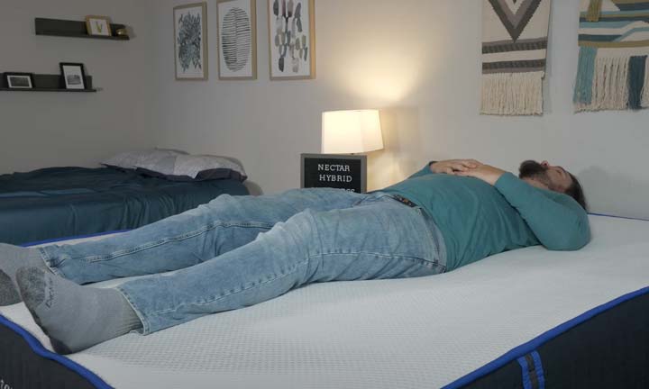 A man sleeps on his back on the Nectar Classic Hybrid.