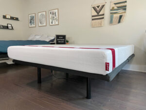 A queen size Juno mattress sits on a base in a bedroom