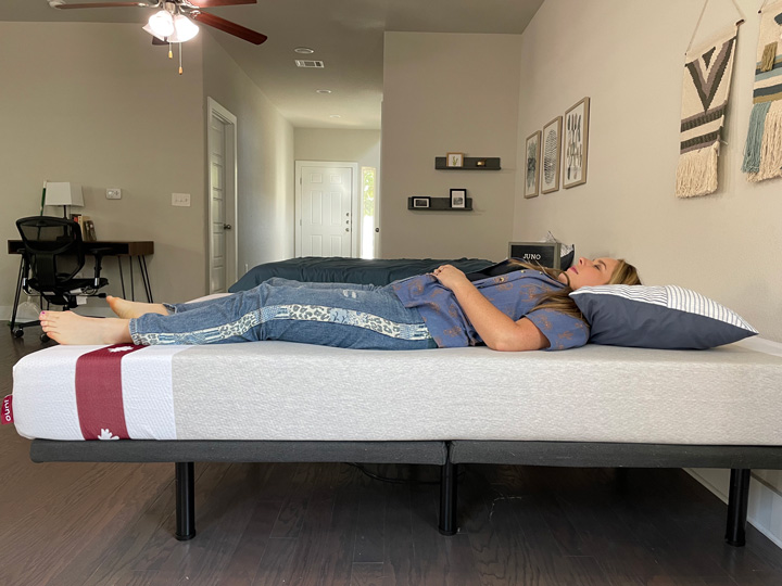 A woman sleeps on her back on the Juno mattress
