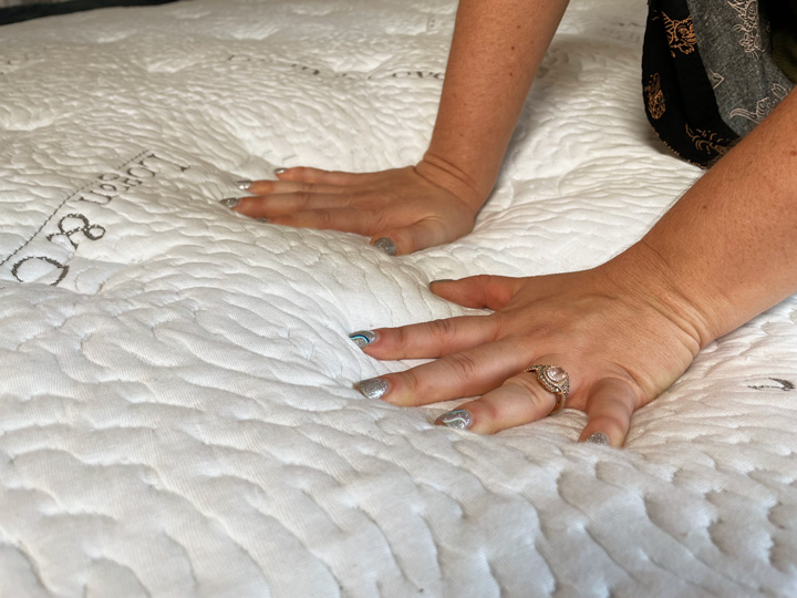 A woman presses into the Logan and Cove mattress