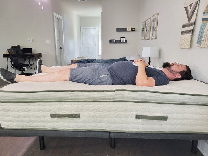 A man sleeps on his back on the Avocado Green mattress