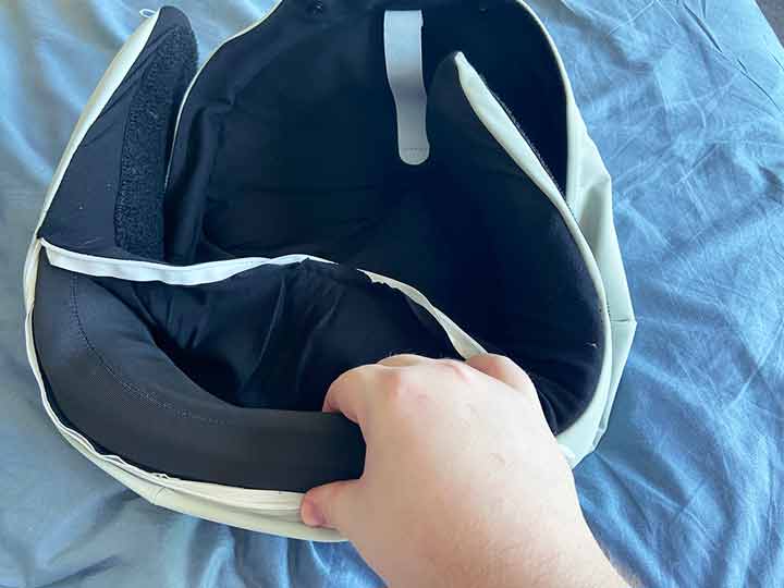 A hand squishes the inside memory foam core of the Pluto POD pillow.