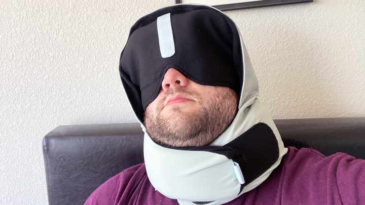 A man uses the Pluto Pod pillow with the eye cover.