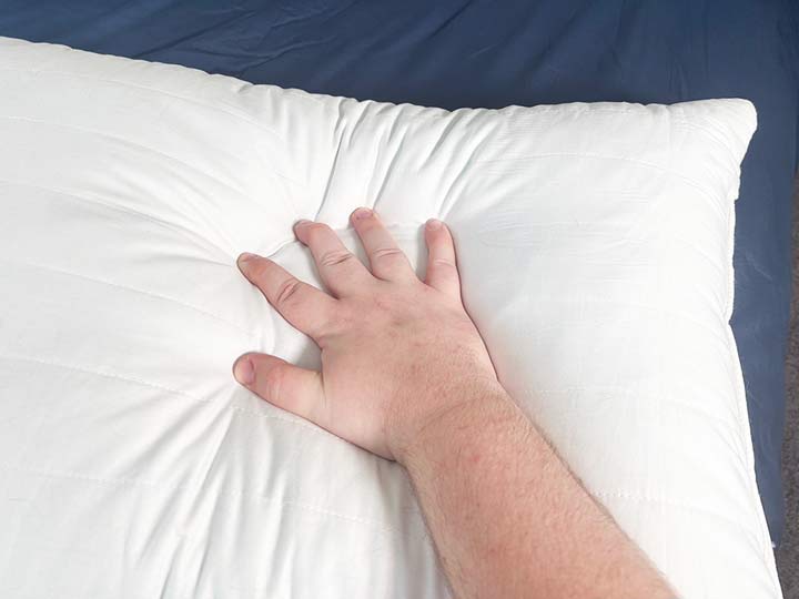 A hand presses into the Marlow pillow.