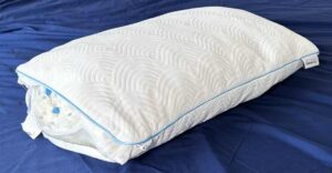 An image of the TEMPUR-Cloud adjustable pillow on top of navy colored sheets.