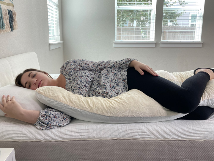 A woman sleeps on her side on the Yana 360 body pillow