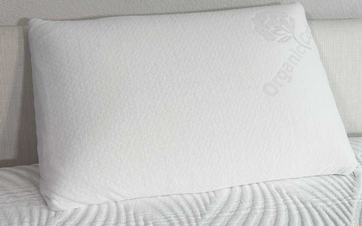 An image of the Brooklyn Bedding Talalay Latex pillow propped up against a headboard.