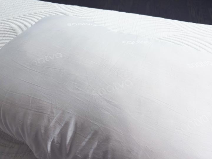 An image of the white cotton cover of the Saatva Down Alternative Pillow.