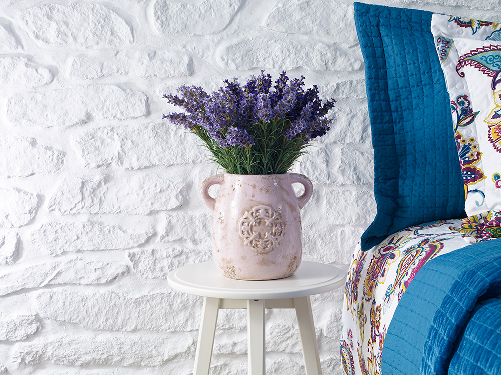 a lavender plant sits next to a bed