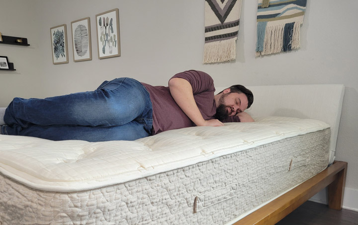 A man sleeps on his side on the Lytton Signature mattress